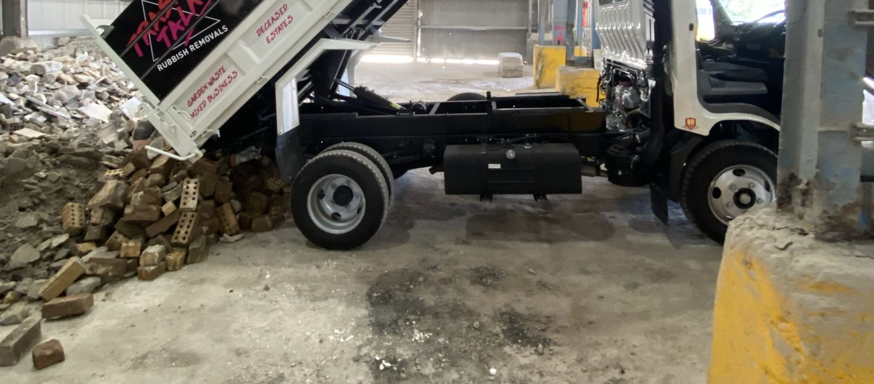 The Trash Talk tipper truck unloading a pile of bricks